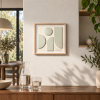 Une œuvre de Lucie garnier vue de face qui fait penser à un ange. 4 plaques de métal très légèrement teintées en vert brillant sont collés sur un fond beige texturé. L’œuvre est encadrée par un cadre en bois clair. La signature de l’artiste est gravée en bas à droite de l’œuvre. And un environment moderne avec une carafe et des plantes 